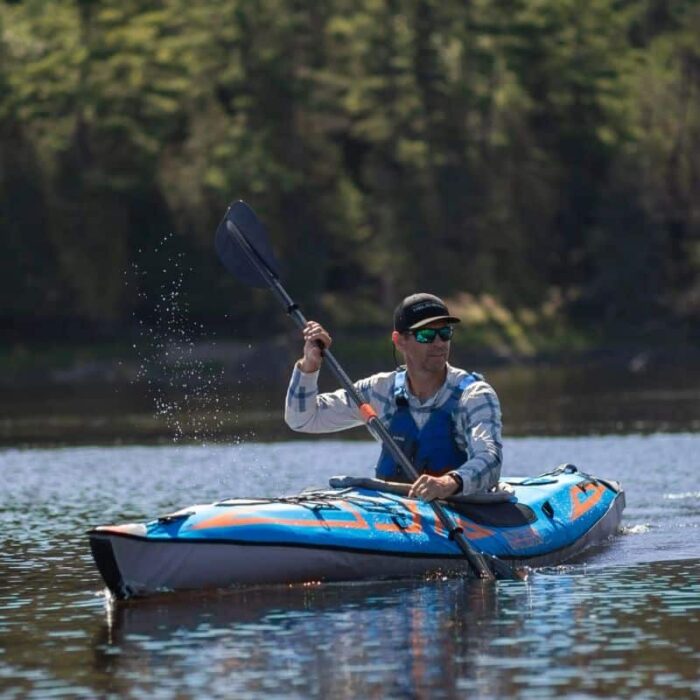 Man paddling the AdvancedFrame Expedition Elite Inflatable Kayak on a calm lake