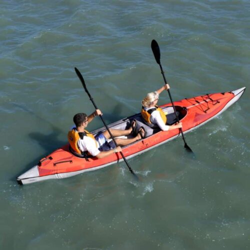 Two people paddling the AdvancedFrame Convertible Elite tandem inflatable kayak on calm water