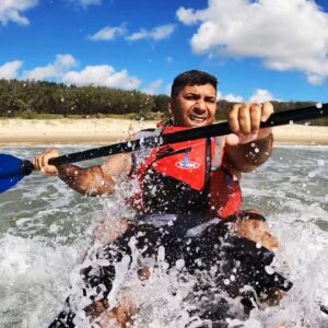 Kayaker paddling into a breaking wave with confidence
