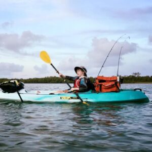 Child paddling a viking espri loaded with fishing gear on calm waters