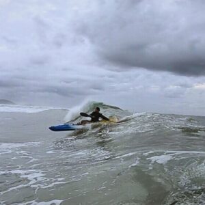 Kayaker navigating large waves on a stormy day