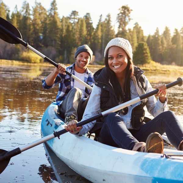 Services 14 Couple kayaking while smiling at a drone and water-level camera