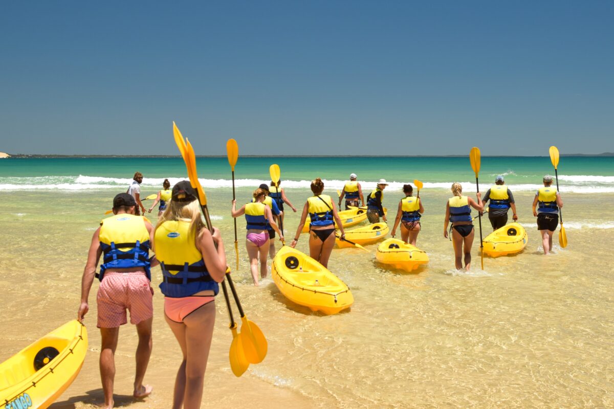 Group of kayakers heading into the surf at Rainbow Beach