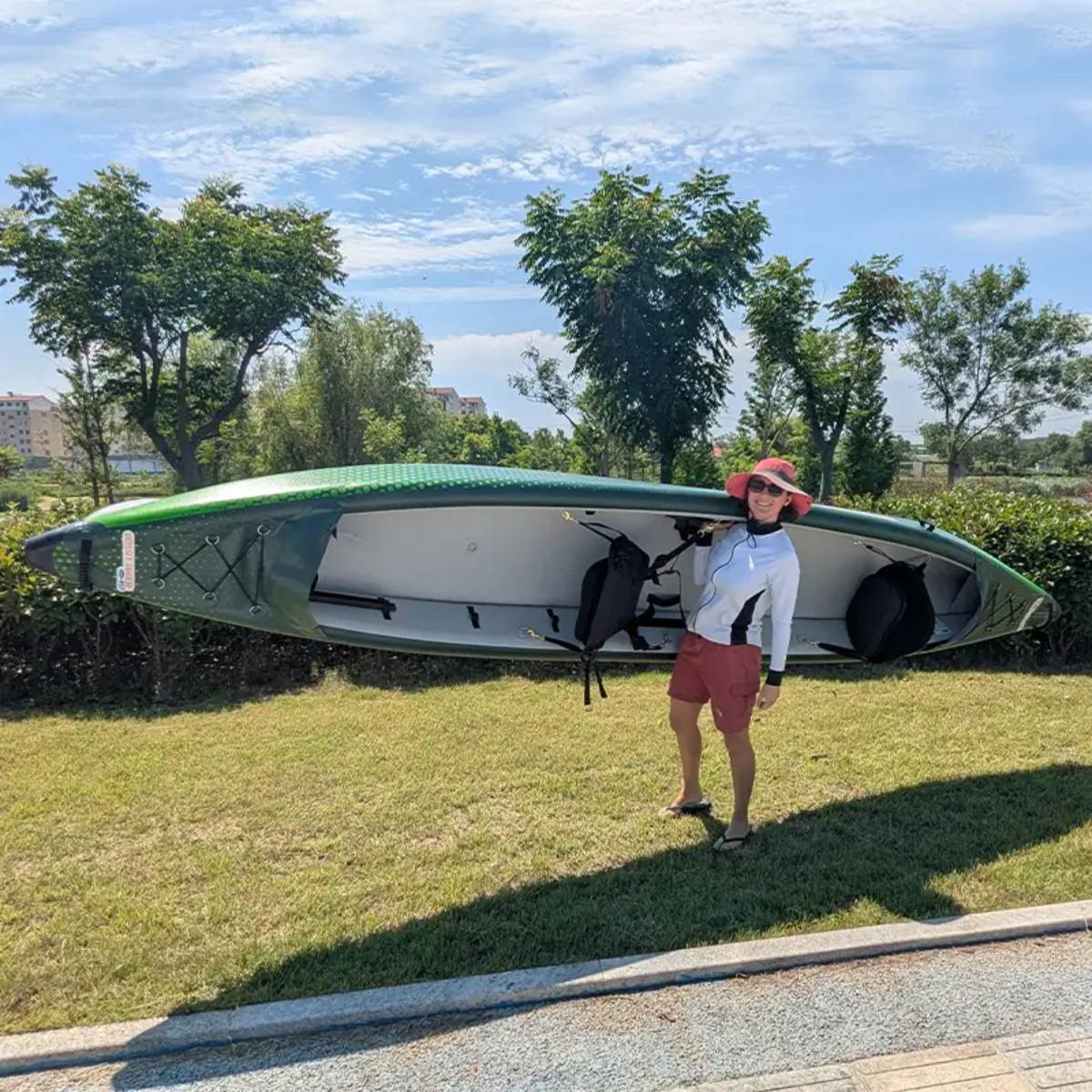 Person carrying the Odyssey Tandem inflatable kayak