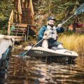 Angler paddling a Pelican Catch PWR 100 near a wooden dock