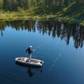 Angler fishing from a Pelican Catch PWR 100 on a calm lake