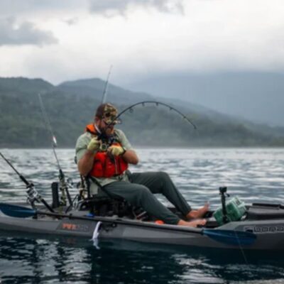 Angler fighting a fish from a Bonafide PWR129 kayak in open water.