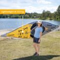 Lightweight inflatable kayak being carried by woman, 13.5 kg portable design